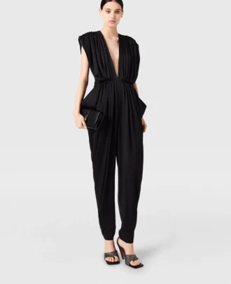 Djup V-ringad jumpsuit med axelvaddar och veck