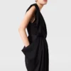 Djup V-ringad jumpsuit med axelvaddar och veck Djup V-ringad jumpsuit med axelvaddar och veck