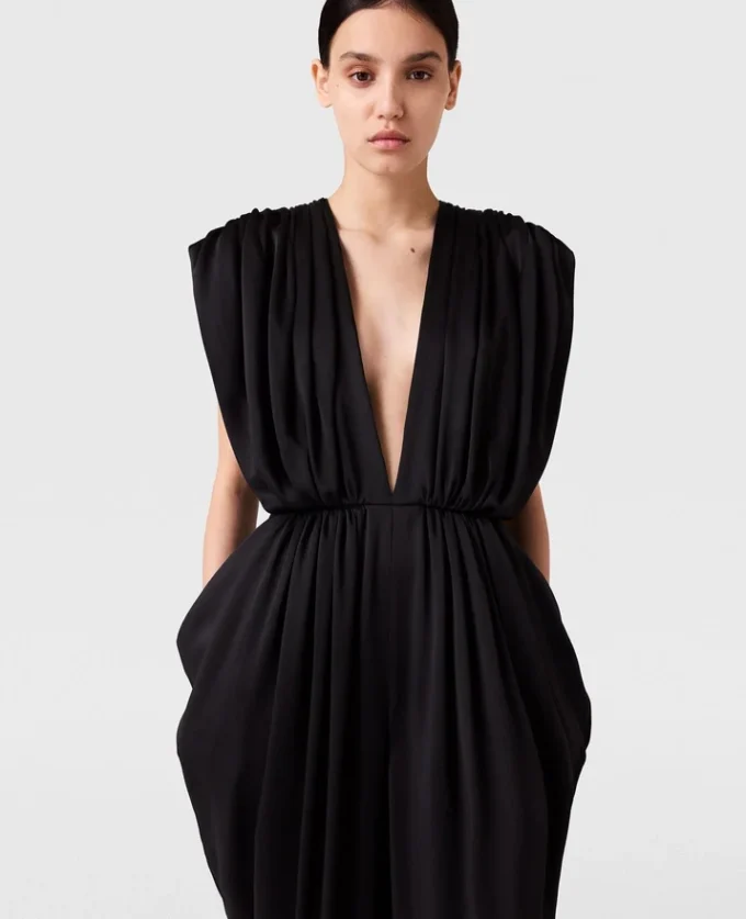 Djup V-ringad jumpsuit med axelvaddar och veck Djup V-ringad jumpsuit med axelvaddar och veck